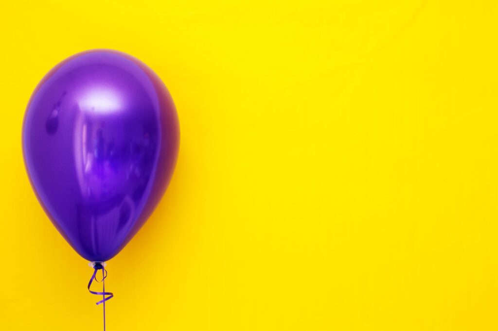 purple balloon against yellow background